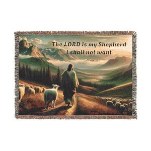 Può includere: Una coperta in tessuto a trama con un paesaggio panoramico di un pastore che guida un gregge di pecore. Il testo "The LORD is my Shepherd I shall not want Psalm 23:1" è stampato sulla coperta.