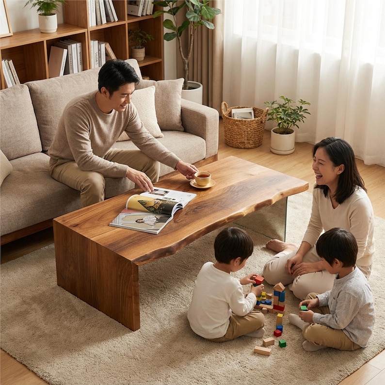 May include: A family is gathered around a large, rectangular wooden coffee table with a live edge. The table is a rich brown color and has a natural, organic shape. The family is sitting on a beige carpet and enjoying each other's company.