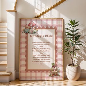 Puede incluir: Un cuadro enmarcado con el texto "Monday's Child" y un poema sobre las características de los niños. El marco tiene un borde a cuadros rosa y blanco con ilustraciones de criaturas del bosque y una seta. Una planta en maceta está al lado del marco.
