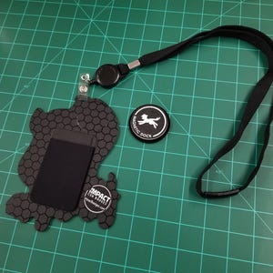 Back view of the badge. Orders include lanyard, badge reel, card holder, magnetic dock, and NFC chip for sharing links.