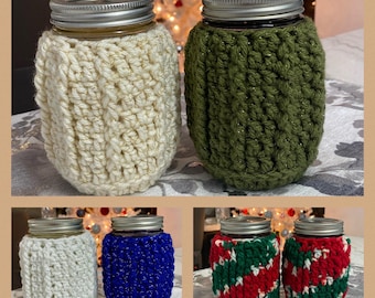 May include: A collage of ten crocheted jar covers in various colors, including white, green, blue, red, and green. The covers are made with a textured stitch and are designed to fit standard-sized mason jars.