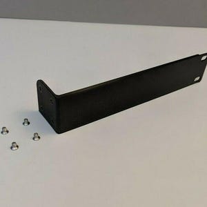 Könnte beinhalten: Ein schwarzer Metallwinkel mit einem rechtwinkligen Knick und mehreren kleinen Schrauben. Der Winkel hat eine rechteckige Form mit zwei kleinen quadratischen Löchern an einem Ende. Die Schrauben sind silberfarben.