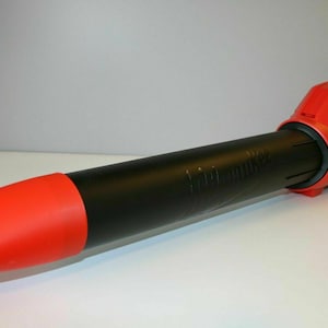 May include: A red and black Milwaukee FUEL cordless leaf blower. The blower has a long, black nozzle with a red tip. The motor housing is red with the Milwaukee logo in white. The blower is designed for outdoor use.