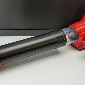 May include: A red and black Craftsman cordless leaf blower with a black nozzle and a separate black nozzle attachment. The blower has a clear plastic section and is on a white surface.