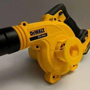 May include: A yellow and black DeWalt 20V MAX cordless leaf blower. The blower has a black nozzle and handle, with the DeWalt logo prominently displayed on the side. The design includes a battery pack.