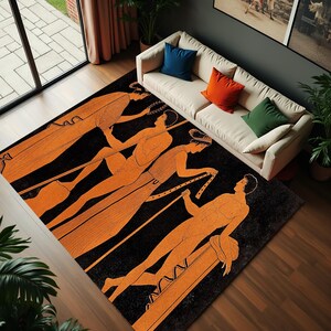 Könnte beinhalten: Ein schwarzer und orangefarbener Teppich mit einem sich wiederholenden Muster aus orangefarbenen Figuren auf schwarzem Hintergrund. Die Figuren sind stilisiert und scheinen Roben zu tragen. Der Teppich liegt auf einem Holzboden.