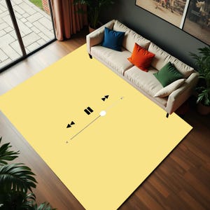 May include: A large, rectangular yellow rug with a minimalist music player graphic. The rug features a play/pause button, rewind, and fast forward symbols in black. A white sofa with colourful throw cushions sits on the rug, creating a modern living room aesthetic.