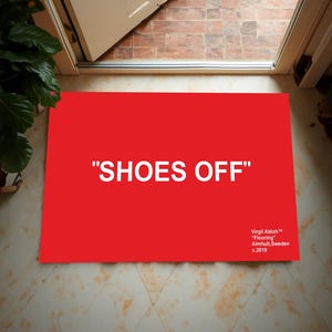 May include: A red doormat with the text "SHOES OFF" in white lettering. The doormat also includes the text "Virgil Abloh™ "Flooring" Almhuit, Sweden c.2019" in smaller white lettering.
