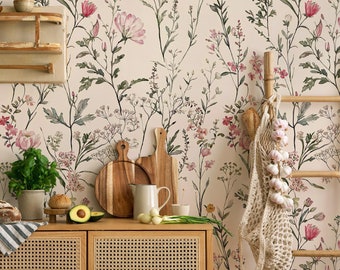 May include: A kitchen with a floral wallpaper featuring pink and green flowers. The kitchen has a wooden cabinet with a woven rattan front, a wooden chair with a woven rattan seat, and a wooden ladder with a string bag hanging from it.