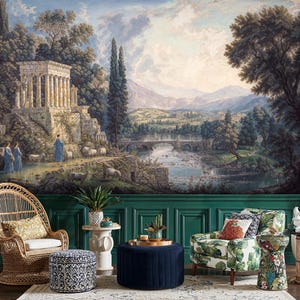 May include: A scenic mural depicting a classical landscape with a temple, figures, and sheep near a river and bridge. The room features a wicker chair, patterned ottoman, floral armchair, and a navy blue ottoman with a gold tray.