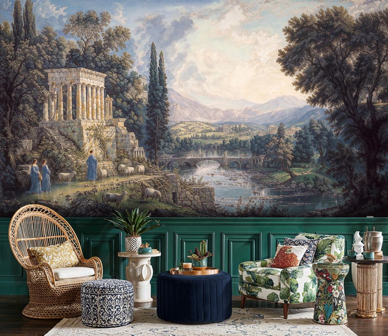 May include: A scenic mural depicting a classical landscape with a temple, figures, and sheep near a river and bridge. The room features a wicker chair, patterned ottoman, floral armchair, and a navy blue ottoman with a gold tray.