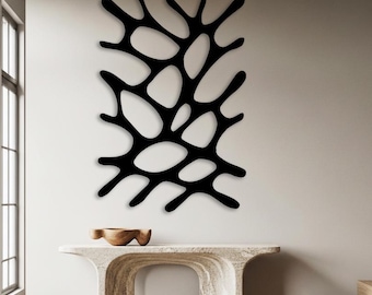 Könnte beinhalten: Ein großes, schwarzes, abstraktes Wandkunstwerk mit einem organischen, verzweigten Design. Das Kunstwerk ist an einer weißen Wand über einem Konsolentisch aus Stein angebracht. Ein kleiner Holzschemel und eine Holzschale sind ebenfalls zu sehen.