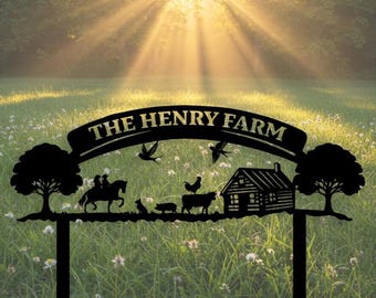 May include: Black metal farm sign with the text "THE HENRY FARM". The sign features silhouettes of a horse and rider, farm animals, a cabin, trees, and birds. The background is a sunny field.
