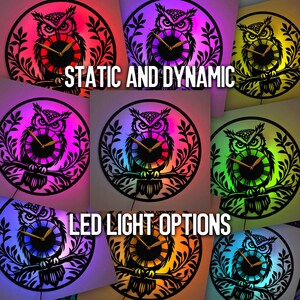 May include: A collection of owl-themed wall clocks with LED lighting. The clocks feature a black owl silhouette design with Roman numeral clock faces. The clocks are illuminated with various colors, including red, purple, green, and blue. Text on the image reads "STATIC AND DYNAMIC" and "LED LIGHT OPTIONS."