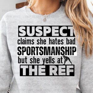 May include: A gray sweatshirt with the text "SUSPECT claims she hates bad SPORTSMANSHIP but she yells at THE REF" in black.