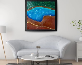 May include: A square framed painting featuring a central blue pool filled with white star-like sparkles, bordered by textured brown earth tones and a thin gold line, set against a dark green background with small white light points.