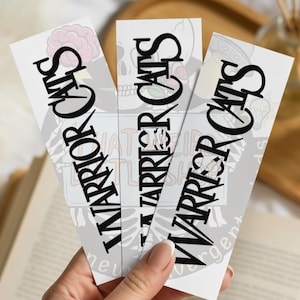 May include: Three white bookmarks with the text "WARRIOR CATS" in bold black letters. Each bookmark has a different background design, including a skull, a brain, and a lightning bolt. The bookmarks are held in a hand.