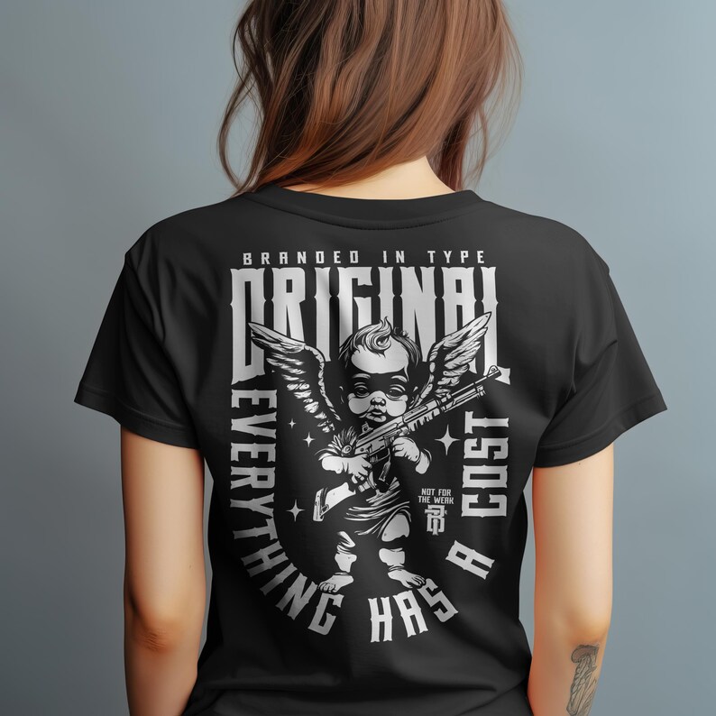 Puede incluir: Camiseta negra con un dise&ntilde;o blanco de un querub&iacute;n sosteniendo una ametralladora, alas y el texto "BRANDED IN TYPE ORIGINAL EVERYTHING HAS A COST". El dise&ntilde;o incluye estrellas y el texto "NOT FOR THE WEAK".