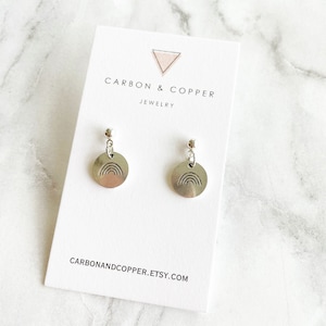 May include: Silver earrings with a rainbow design. The earrings are on a white card with the text "CARBON & COPPER JEWELRY" and "CARBONANDCOPPER.ETSY.COM".