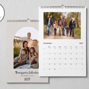 May include: A wall calendar for 2027 featuring a spiral binding and a hanger. The cover displays a family photo in an arch frame with the text Thompson's Calendar A wonderful year! 2027. The open page shows a November 2027 grid and a family photo.