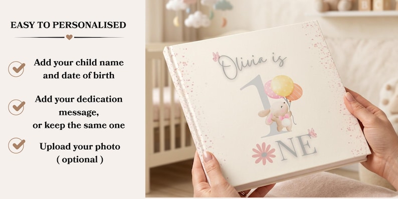 May include: A square photo album with a cream-colored cover featuring the text 'Olivia is 1 NE' in gray and pink. The design includes a watercolor illustration of a bunny holding three pastel balloons, pink butterflies, and a pink flower. The left side lists personalization options including adding a name, date of birth, and dedication message.