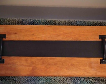 Könnte beinhalten: Ein Holztablett mit einem schwarz lackierten Streifen und zwei schwarzen Metallgriffen.