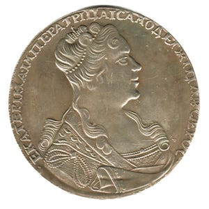 Puede incluir: Una moneda de plata que presenta el perfil de una mujer con cabello y vestimenta ornamentados. La moneda tiene texto alrededor del perímetro. La mujer lleva una corona y un vestido detallado. La moneda es circular y tiene un aspecto ligeramente deslustrado.