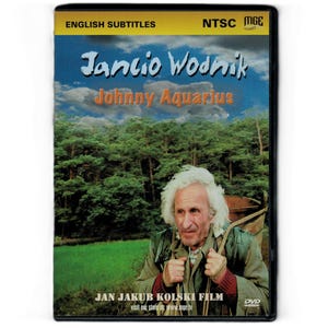 May include: A DVD case for the film Jancio Wodnik, also titled Johnny Aquarius. The cover features an older person with white hair carrying a wooden tub on their back against a forest and sky background. Text includes English Subtitles and NTSC.