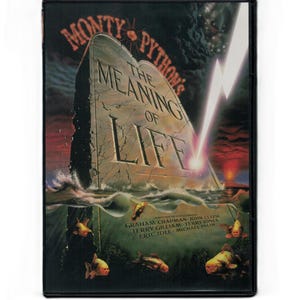 May include: A VHS tape of Monty Python's "The Meaning of Life". The cover shows a tombstone rising from water, with the film's title and credits. Goldfish swim in the foreground, with a lightning bolt in the background.