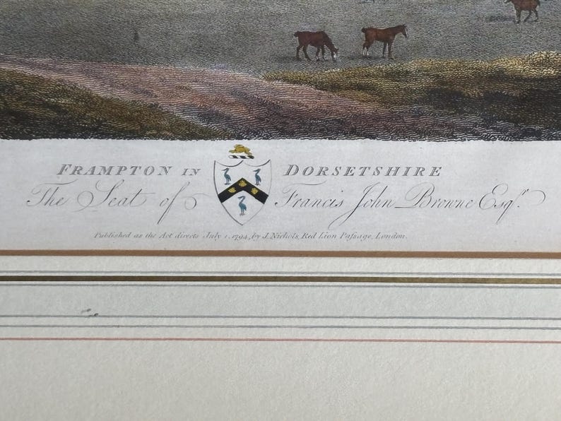 May include: An antique print depicting a pastoral scene with horses grazing in a field. The print includes text that reads "FRAMPTON IN DORSETSHIRE" and "The Seat of Francis John Browne Esq.". The print has a crest and is framed with decorative lines.