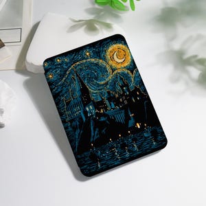 May include: A black tablet case featuring a starry night design with a castle silhouette, a crescent moon, and a swirling sky in shades of blue and gold. The case has a glossy finish and a rectangular shape.