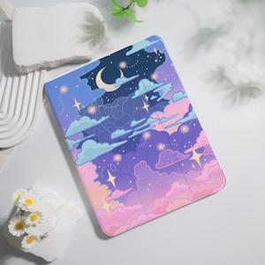 May include: A tablet case featuring a dreamy night sky design. The case showcases a gradient of colors, including pink, purple, blue, and white, with illustrations of clouds, stars, and a crescent moon. The case is designed to protect the tablet.