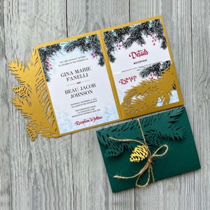 Puede incluir: Invitación de boda cortada con láser en oro y verde con un tema de bosque de invierno. La invitación presenta un diseño de pino con bayas rojas y el texto "Están cordialmente invitados a celebrar la boda de Gina Marie Fanelli y Beau Jacob Johnson. Sábado, 17 de diciembre de 2019 a las 3:00 PM de la tarde. The Wildwood Lodge, 123 Crocheton Lane, Middletownship, Nueva York. Recepción a continuación."
