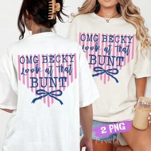 Può includere: T-shirt bianche con la scritta "OMG BECKY look at that BUNT" in rosa e blu. Il testo è all'interno di un triangolo a righe rosa e bianche con un fiocco blu in basso. Le magliette sono casual.