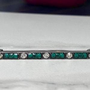 May include: A white ceramic mug with a black handle and the text "But First, Coffee" in a black, handwritten-style font. The mug is on a white surface.