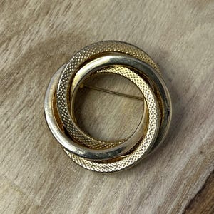 Spilla vintage con cerchi intrecciati color oro Atto II