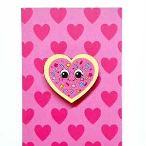 May include: Pink heart-shaped cookie with sprinkles and a smiling face on a pink background with a pattern of pink hearts. The text "www.claireyloucreations.com" is at the bottom of the card.