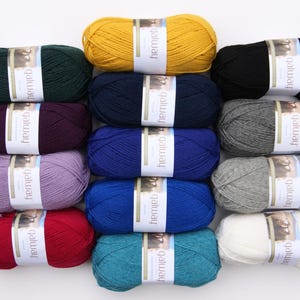 Può includere: Una collezione di 12 gomitoli di filato Galway in vari colori, tra cui giallo, verde, viola, blu, grigio, rosso, verde acqua e bianco. Ogni gomitolo ha un'etichetta con la parola "Galway" stampata su di essa.
