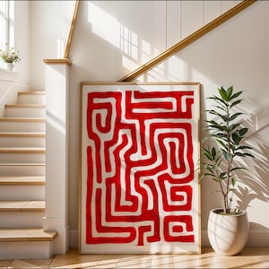 May include: A red and white abstract painting with a maze-like pattern. The painting is framed and hanging on a white wall in a home.