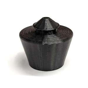 Op de afbeelding: Een zwarte plastic flesstopper met een conische bovenkant en een geribbelde basis.