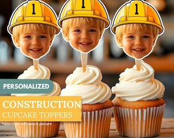 May include: Three cupcakes with white frosting, each topped with a construction worker face wearing a yellow hard hat with the number 1. The cupcakes are labeled "PERSONALIZED CONSTRUCTION CUPCAKE TOPPERS". The toppers are 2.5 x 2.8 inches.