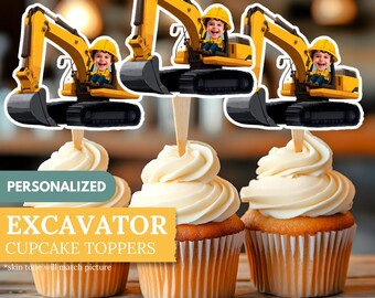 May include: Cupcakes topped with excavator-themed toppers. The toppers feature a yellow excavator with a smiling child in the driver's seat. The cupcakes have white frosting. Text on the image reads "PERSONALIZED EXCAVATOR CUPCAKE TOPPERS".