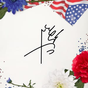 Puede incluir: Una pegatina blanca con un diseño abstracto negro. La pegatina presenta un dibujo lineal estilizado de un símbolo. El fondo incluye una bandera estadounidense, flores rojas y azules y confeti en forma de estrella.