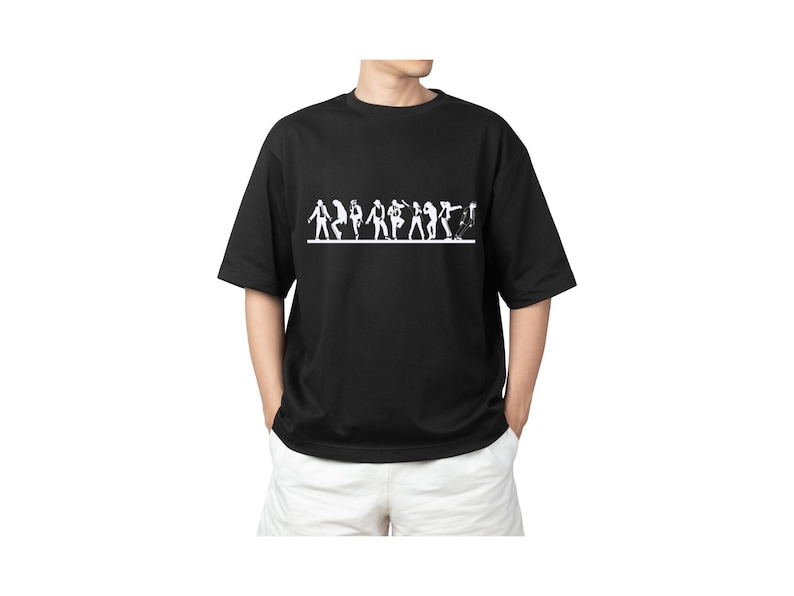 May include: Black t-shirt with a white graphic of stylized figures in various poses, possibly dancing or performing. The shirt has short sleeves and a crew neck. The model is wearing white shorts.