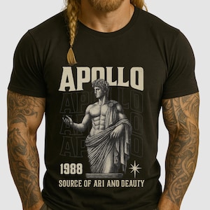 以下が含まれることがあります： アポロ像のグラフィックが特徴の黒いTシャツ。「APOLLO」の文字が上にあり、「1988 SOURCE OF ART AND BEAUTY」の文字が下にあります。クルーネックと半袖のデザインです。