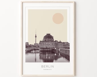 May include: A black and white photograph of the Berliner Dom, a famous landmark in Berlin, Germany. The photo is set against a light beige background with a peach-colored circle in the upper right corner. The text "BERLIN" and "GERMANY" is printed below the image.