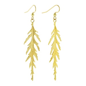 May include: A pair of gold-tone dangle earrings featuring a delicate, fern-like design. The earrings are made of metal and have a hook closure.