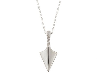 Op de afbeelding: Een zilveren ketting met een klein, driehoekig hangertje. Het hangertje is gevormd als een papieren vliegtuigje.