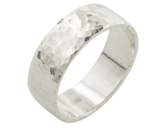 Op de afbeelding: Een zilveren gehammerde bandring. De ring is breed en heeft een getextureerd oppervlak.
