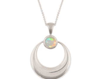 Op de afbeelding: Een zilveren halve maan hanger ketting met een ronde opaal edelsteen in het midden.